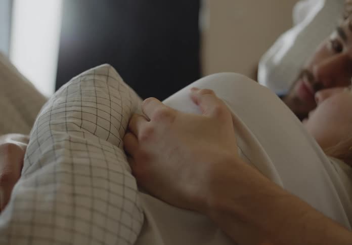 Man and woman are laying in bed together