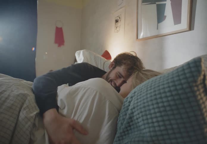 A man and woman cuddling in bed