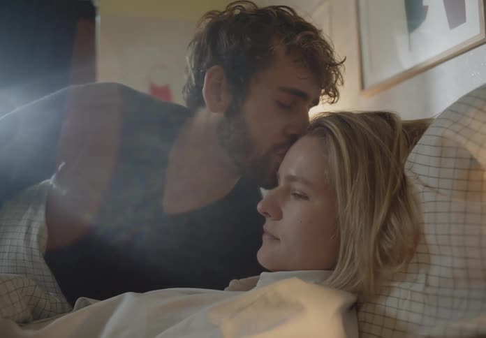 A man is kissing his girlfriend on the forehead