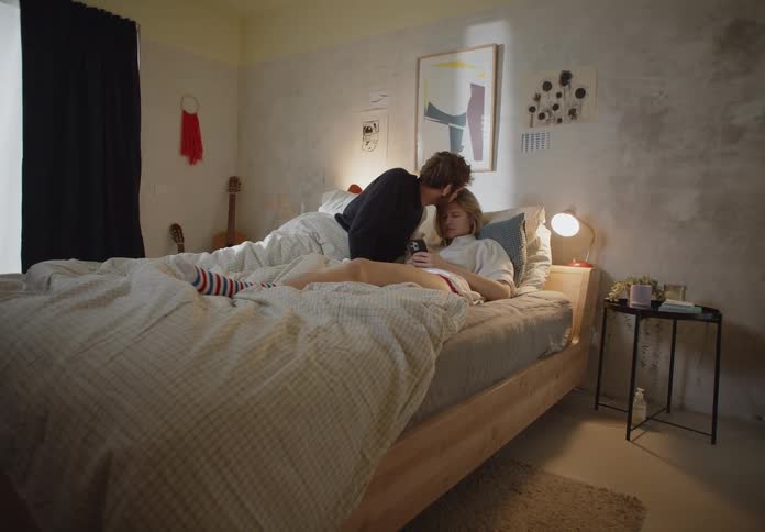 A man kisses a woman in bed