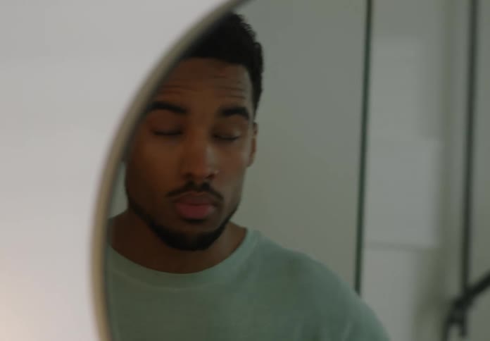 A young man is wiping his face with a towel in the bathroom
