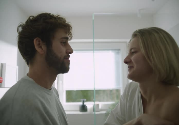 A young couple is being affection with each other in the bathroom