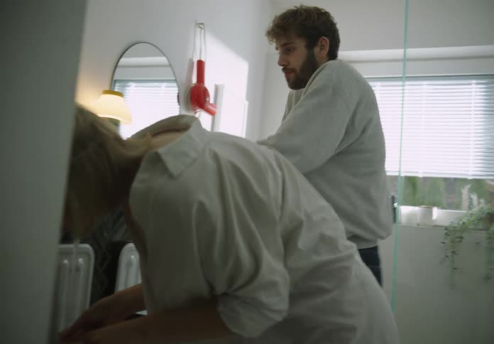 Man and woman are getting ready in the bathroom together