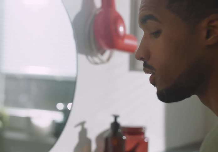 A young man is washing his face in the bathroom