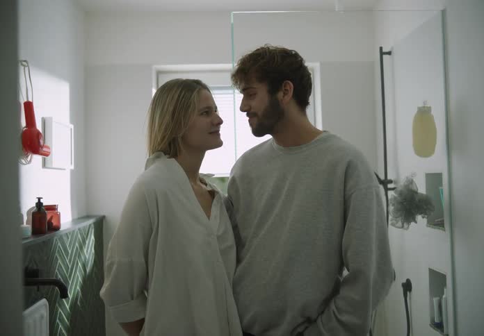 A man and woman pose in the bathroom together