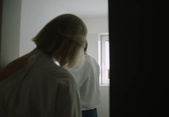 A woman walks into a bathroom where her boyfriend is