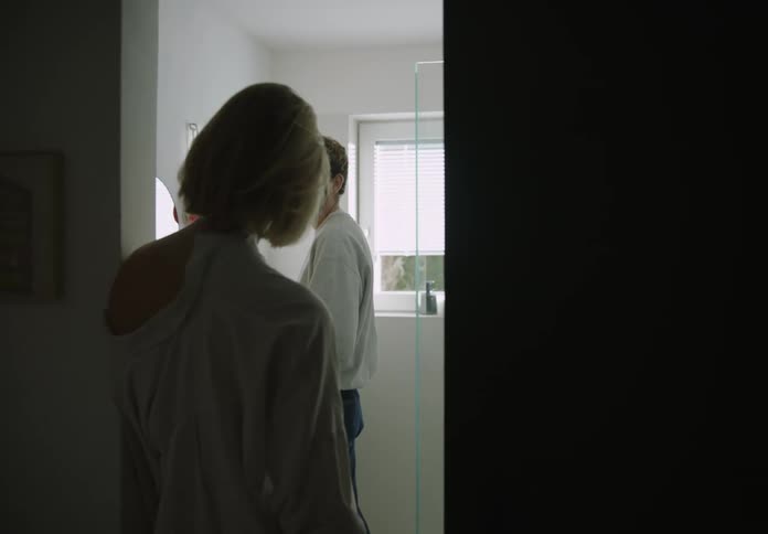 Man and a woman talk in a bathroom during the day