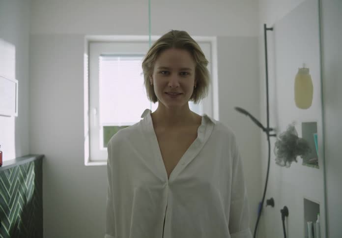 Portrait of a woman smiling and standing in a bathroom