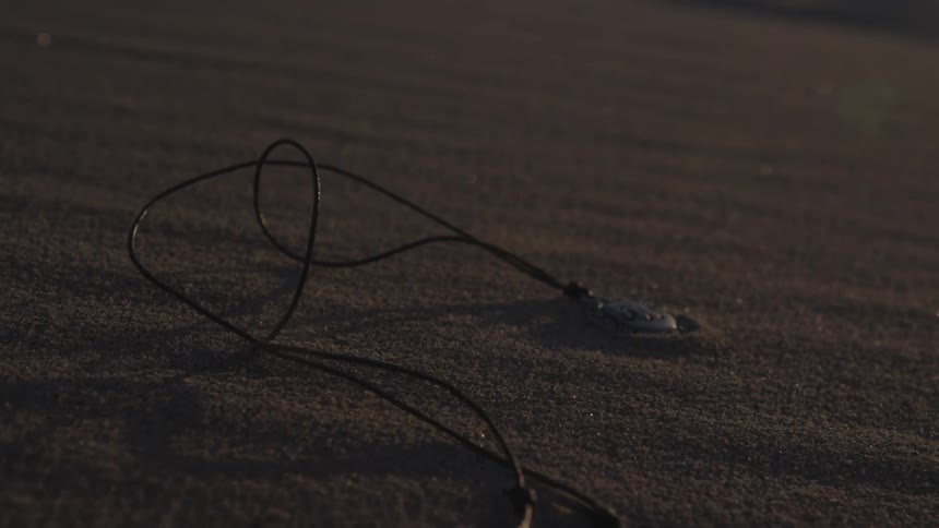 A necklace lies in the sand