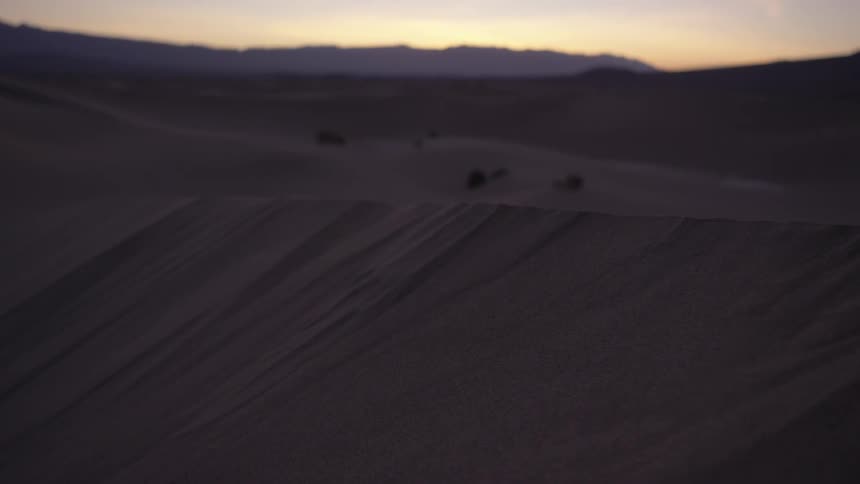 The sun is setting on this hilly desert