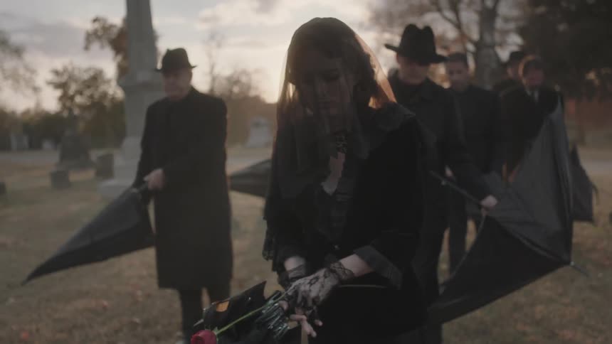 A group of people walk through a cemetery