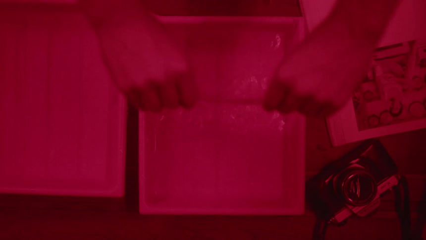 A man develops print photos in a dark room