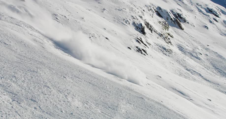 Aerial view of falling snow down a mountain slope during an avalanche