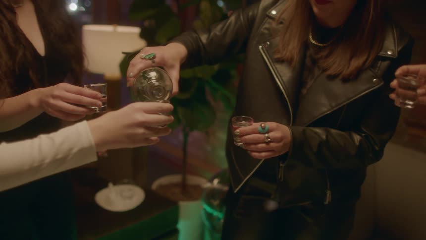 A woman pours drinks at a party