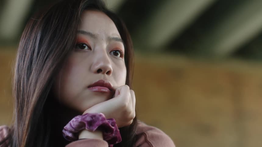 Woman waits with her chin on her hand