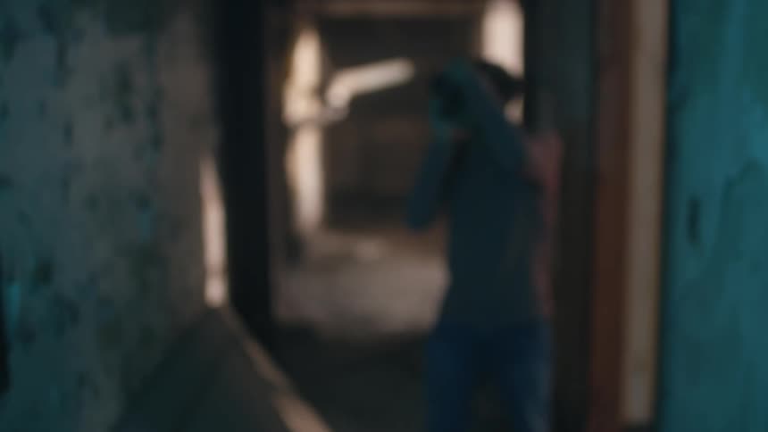 Man with mustache t shirt and jeans takes photo in old abandoned building