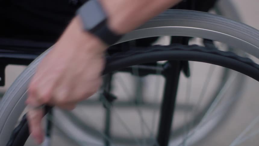 A man uses a wheelchair down the street