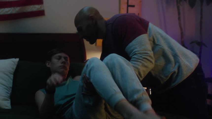 Father lifts son from wheelchair and places him in bed