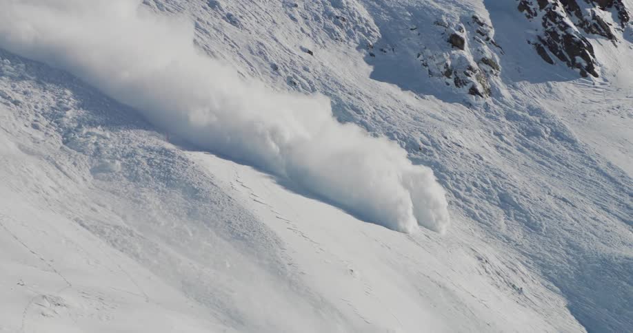 A snow avalanche going down a snowy mountain