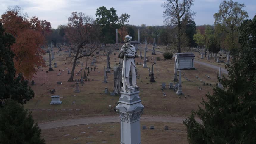 A large statue of a man rises above this cemetery