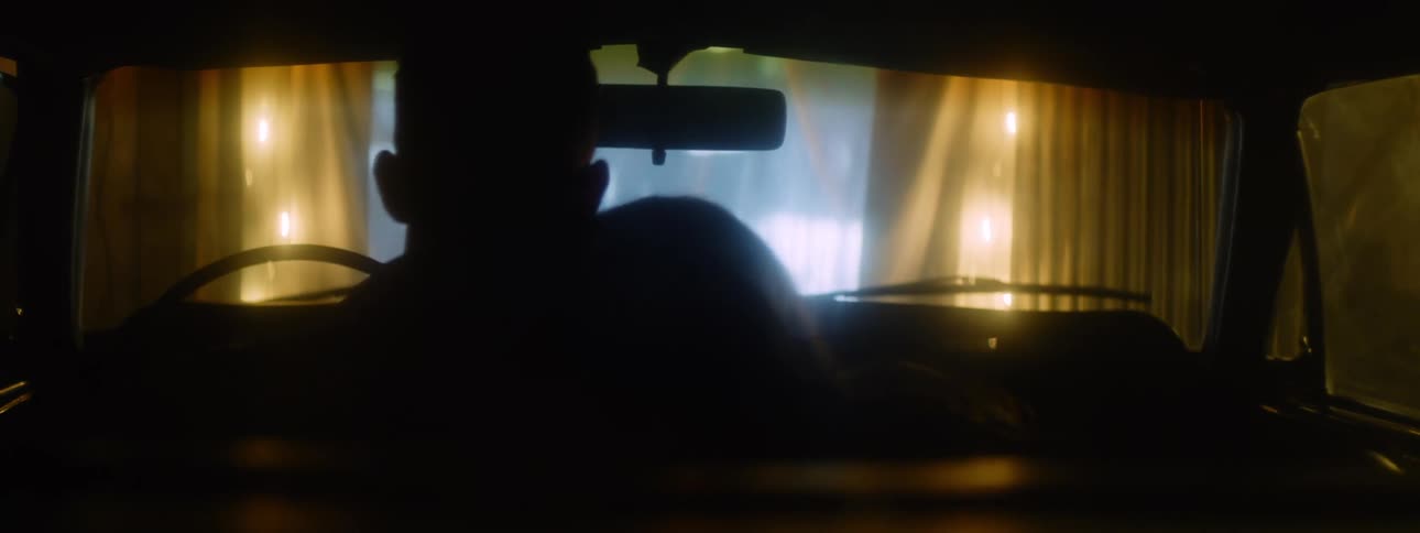 A couple are watching a movie at the drive in