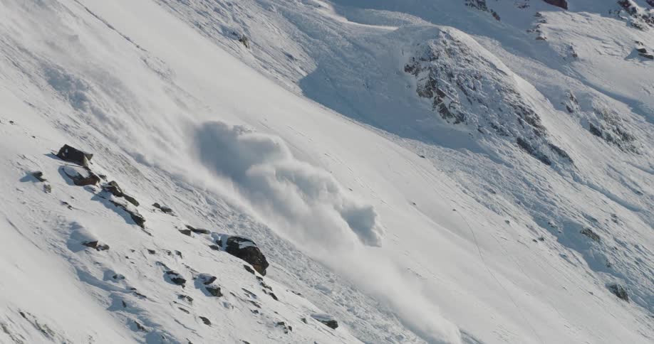 The avalanche moves down the mountain