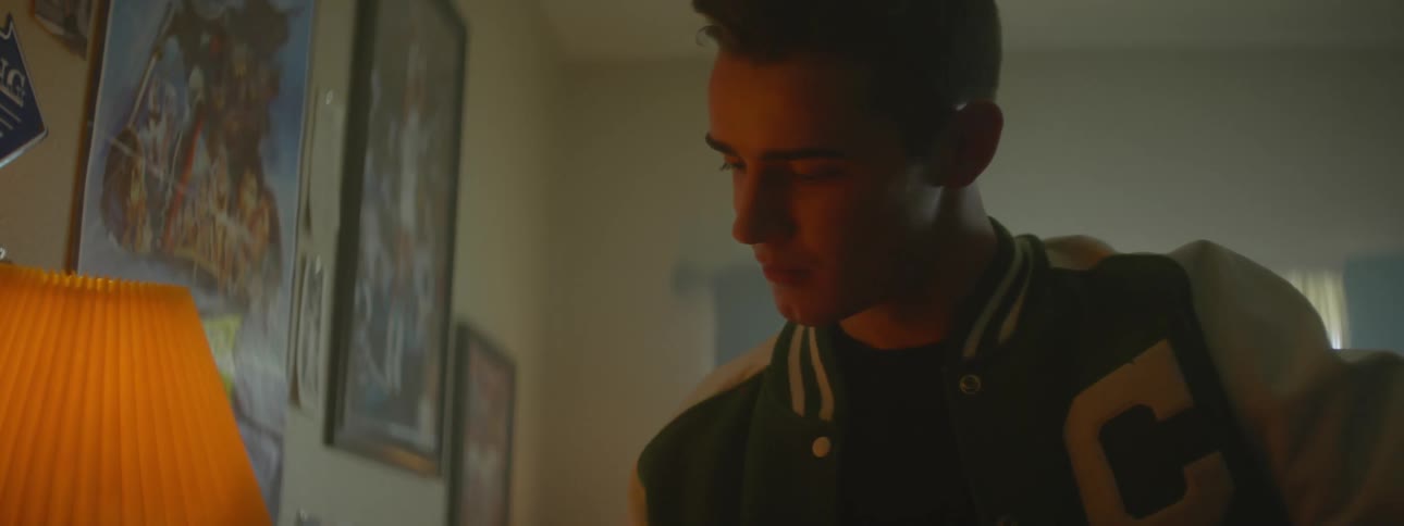 A teenager picks up a toy car on a nightstand