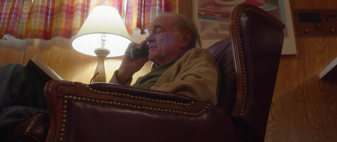 A man talking on a phone in a room