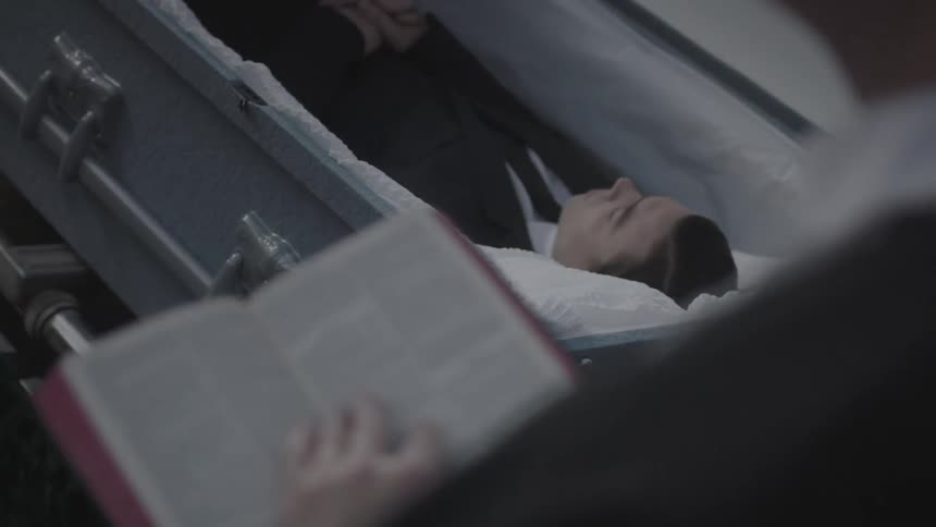 A person reads from the bible at a funeral