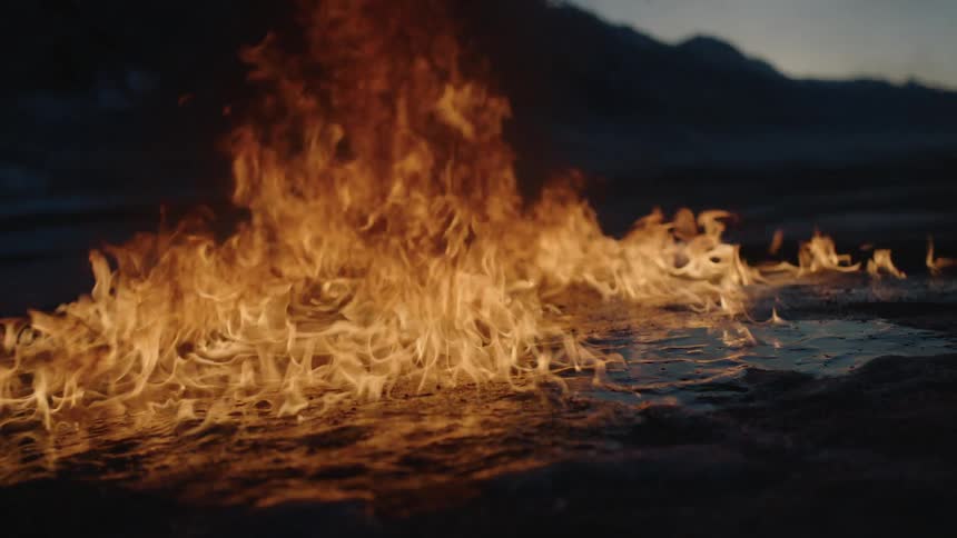 Fire burns outside at night