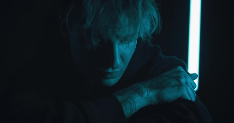 A close up of a man putting his face on his arms looking sad and depressed