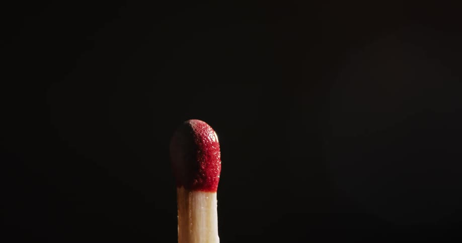 The texture of a stick match moves as it ignites bursting into a flame