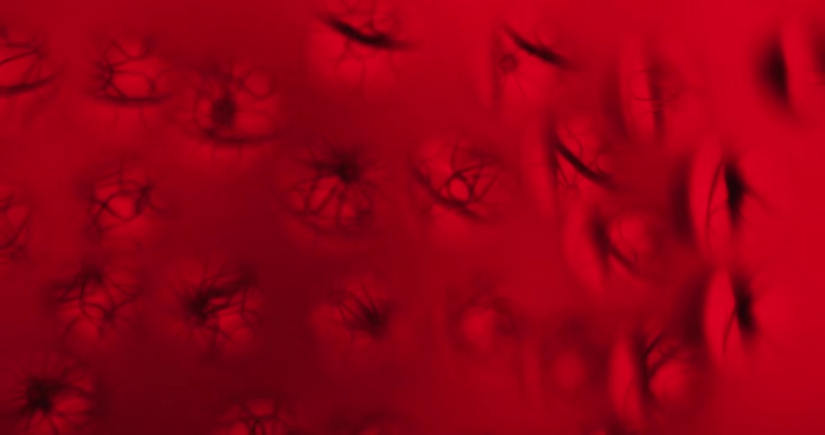 A light moves across a red heavily textured object