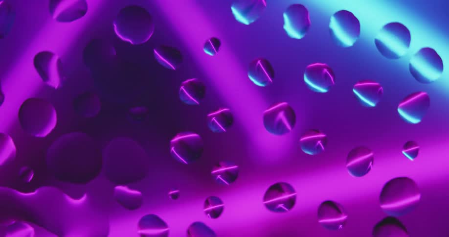 Water droplets sit on clear glass as lines of purple and blue light move behind them reflecting color in the droplets