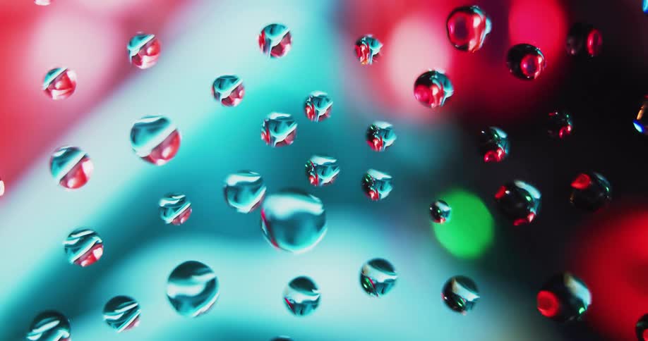 Multiple transparent spheres reflecting spinning colorful lights in the background