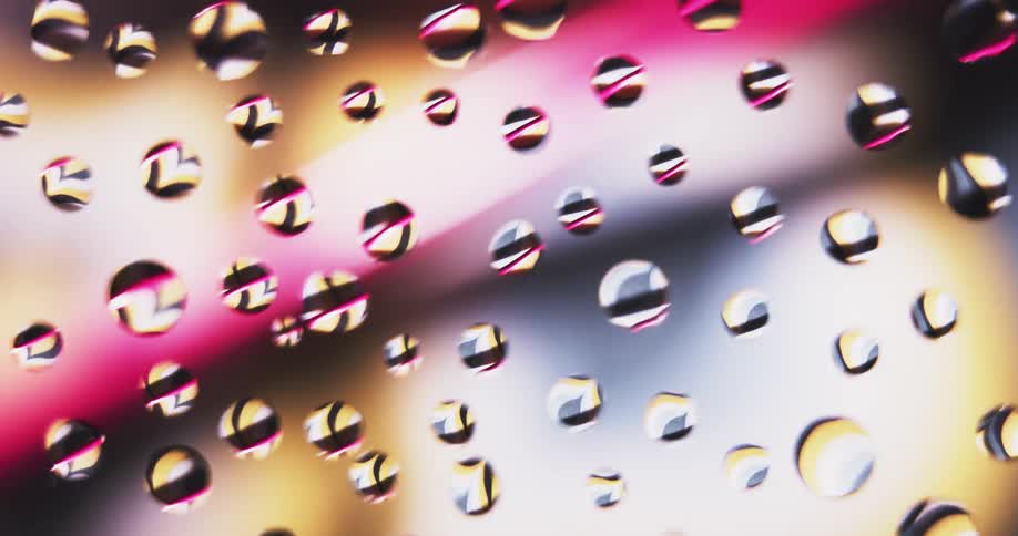 The lights move behind the drops of water