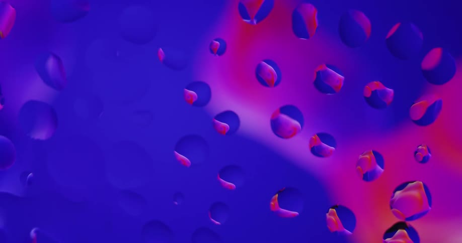 Water droplets sit on clear glass as purple and pink light moves behind them