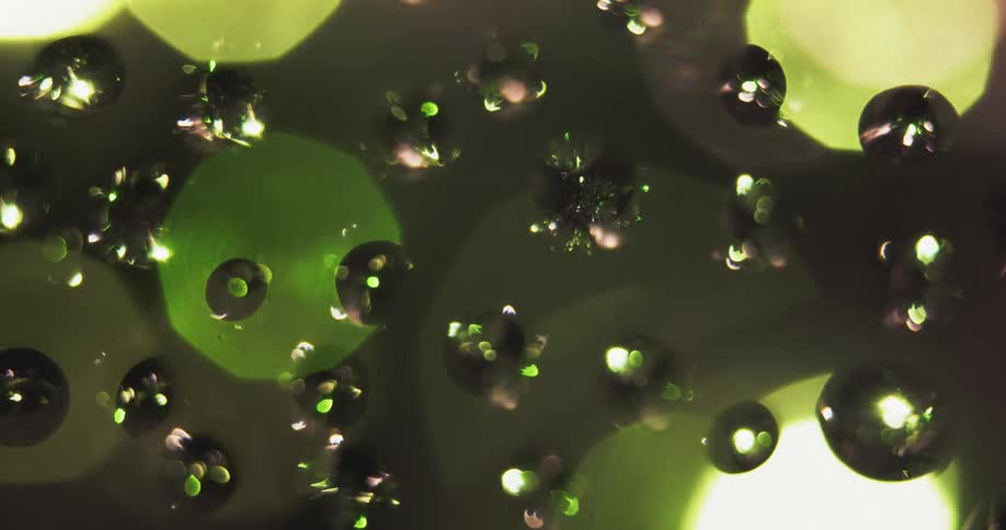 Lights flash behind the water drops