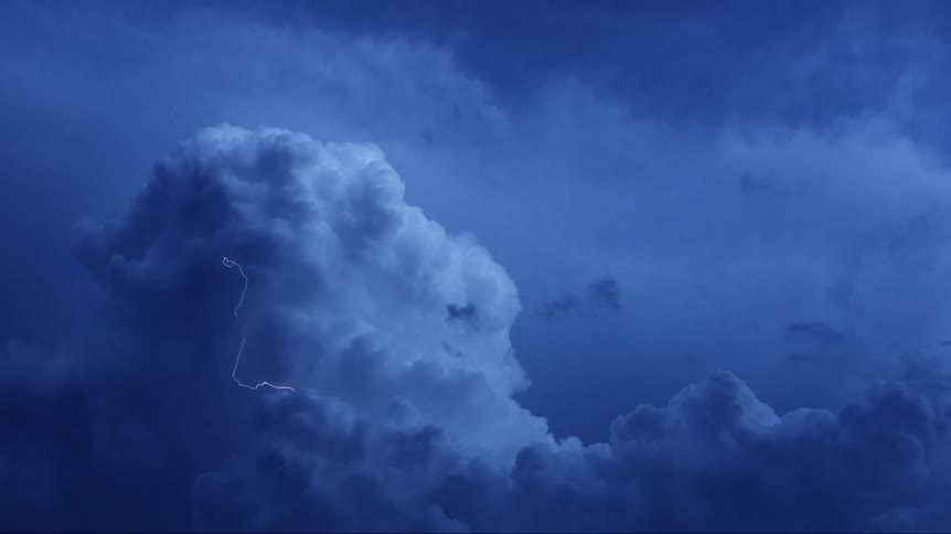 Lightning strikes in large cloud in sky