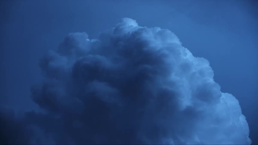 A large storm cloud with lightning flashing in the middle