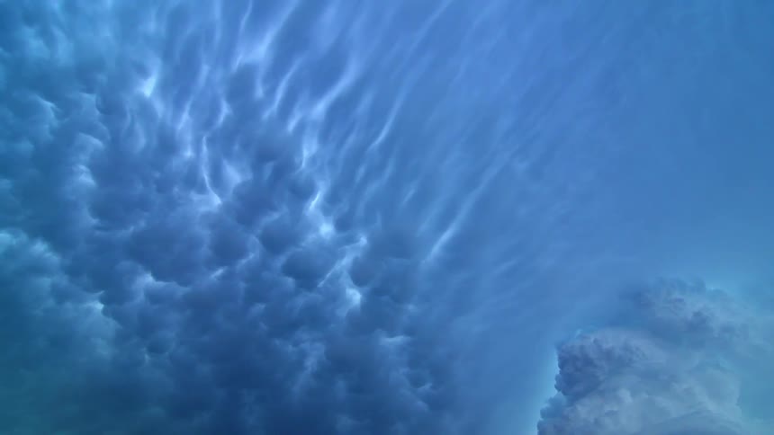 Light glows through clouds in a blue gray sky