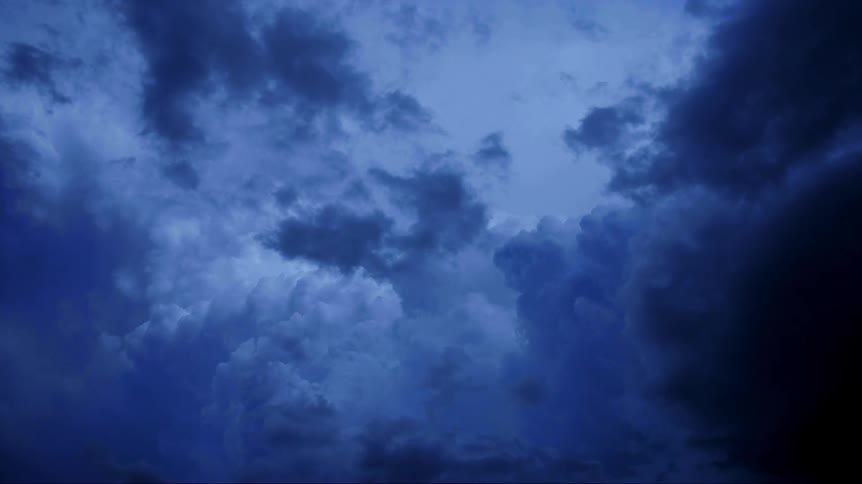 Lightning flashes inside of storm clouds as they move across the sky