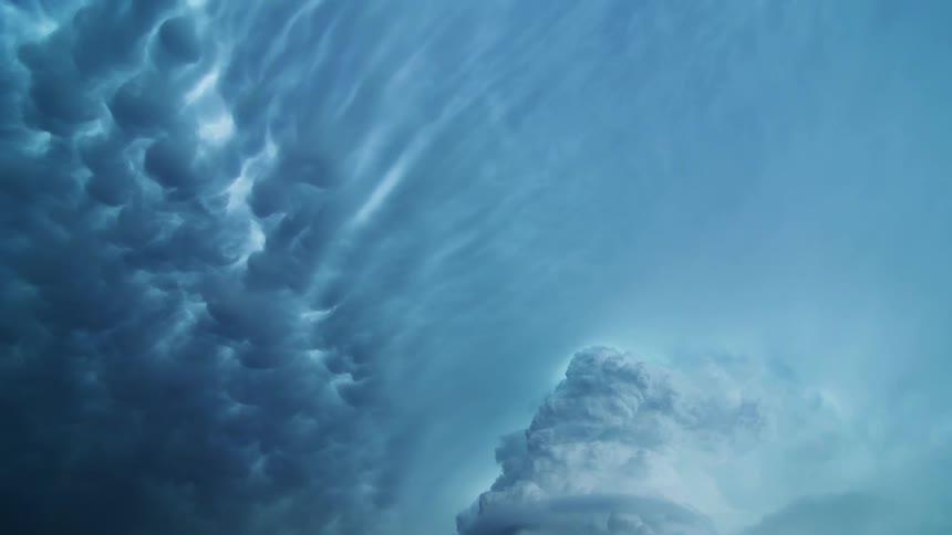 A blue sky with fluffy clouds streamed across