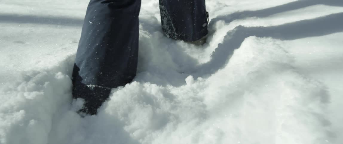 Person walks through snow wearing snowshoes
