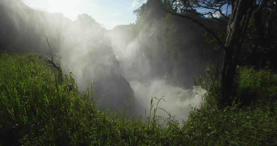 Vapor from waterfall fills valley on sunny day