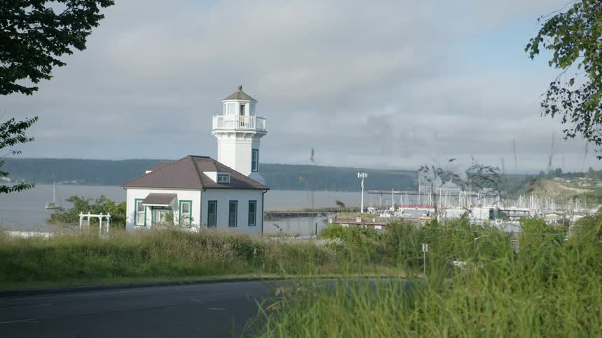 Small lighthouse near a marina on a small rural town close to a lake at daytime