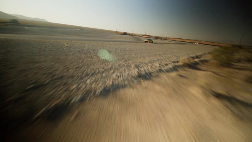 A vehicle speeds down a rural highway