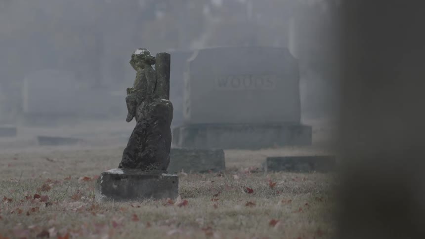 A statue sits on one of these tombstones
