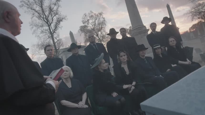 Mourners gather at a funeral in a cemetery