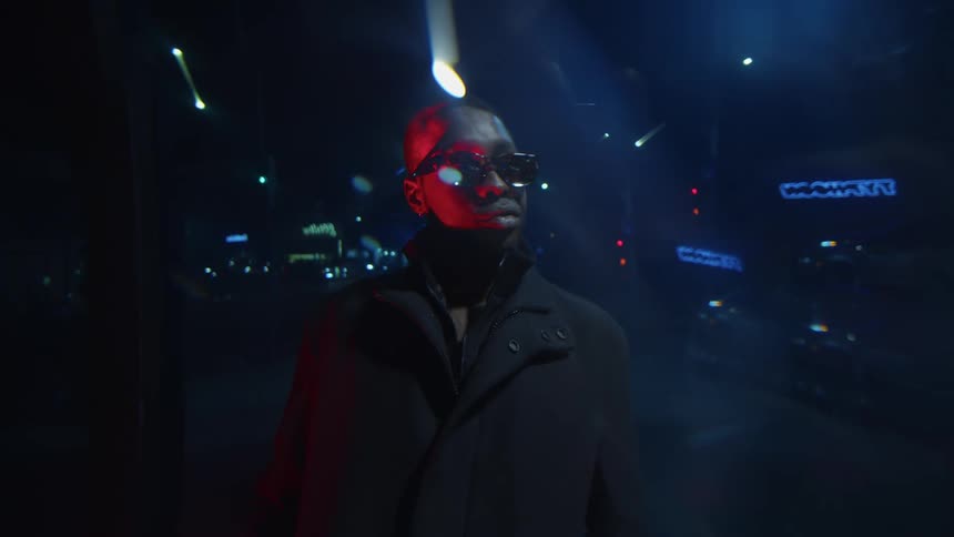 Man stands with his back to busy street at night